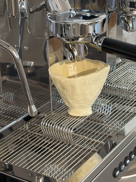 Handgemachte Keramiktasse unter einer Espressomaschine beim Coffee & Clay Workshop in Gmunden
